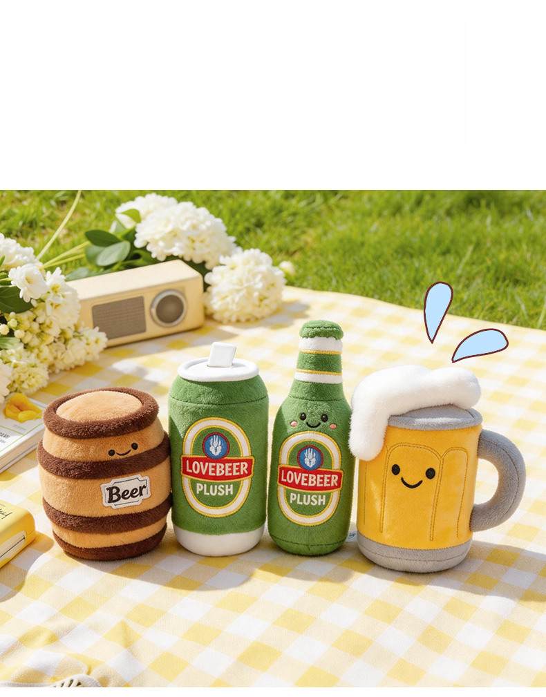 Outdoor picnic scene displaying kawaii beer barrel, can, bottle, and mug plush toys on a yellow checkered blanket.