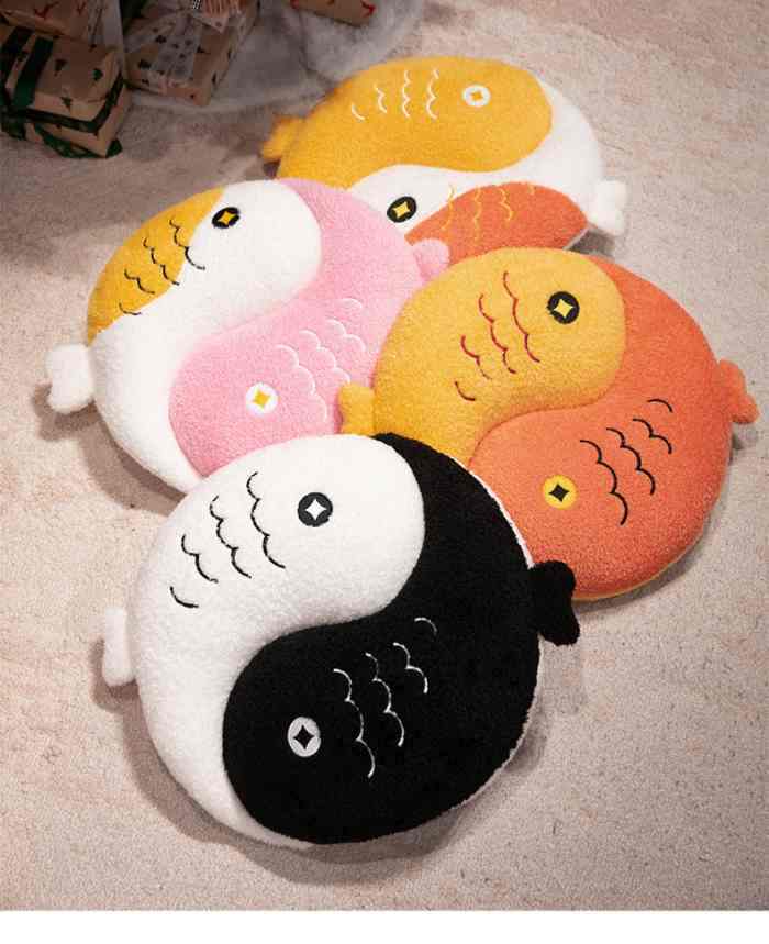 Collection of four aesthetic Yin Yang Koi fish plush pillows in black, pink, orange, and yellow on a cozy rug.