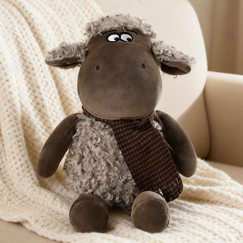 Custom brown sheep stuffed toy with plaid scarf on a cream knit blanket for OEM factory sourcing.