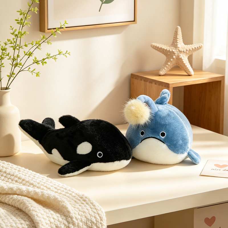 B2B orca killer whale and blue anglerfish plushies displayed on a desk for room decor wholesale.