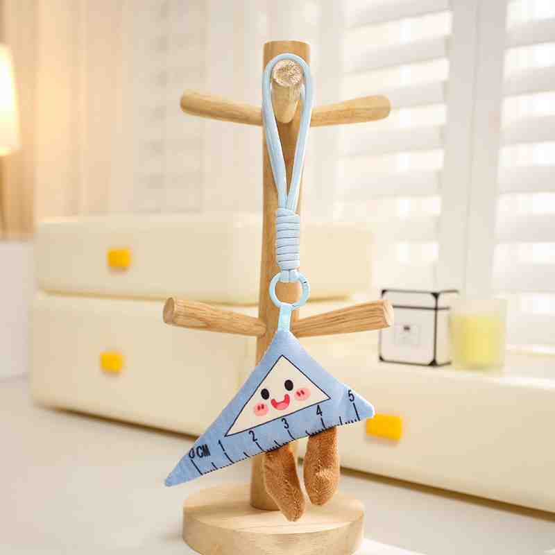 Small blue triangle ruler plush keychain with a kawaii face and brown legs, funny math student gift.
