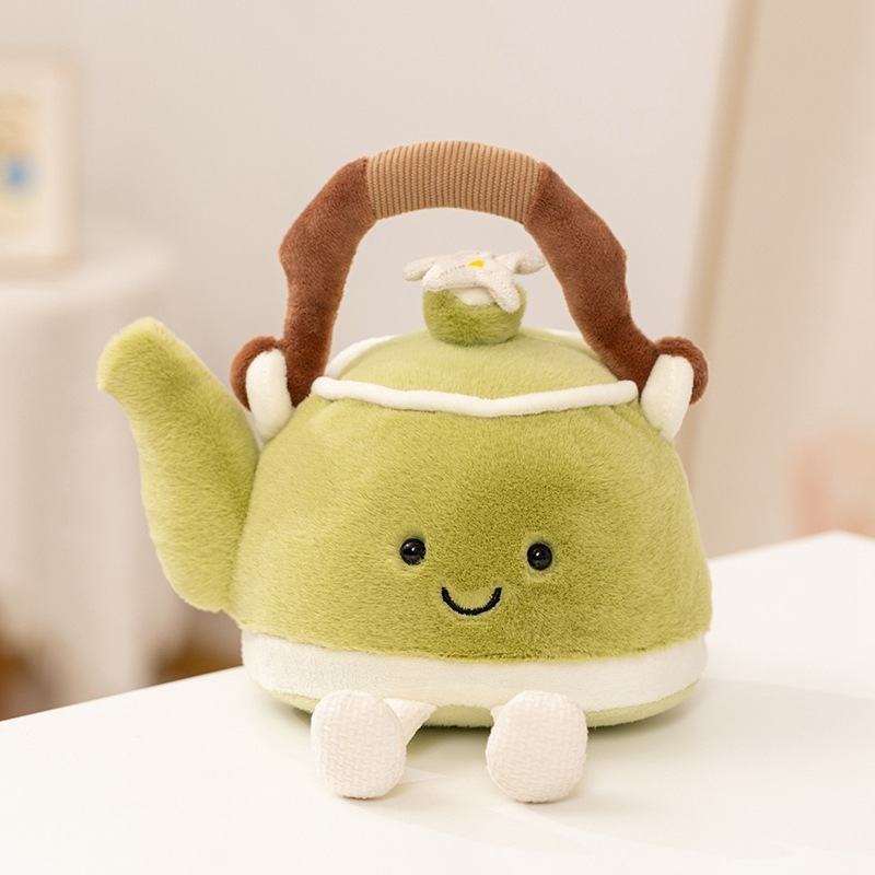 Aesthetic green teapot plushie sitting on a white desk for boutique supply and wholesale.