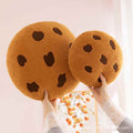 Bulk custom chocolate chip biscuit cushions held in hands for boutique home decor vendors.