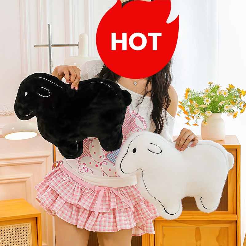 Bulk custom black and white sheep plushies held by model for boutique retail vendors.