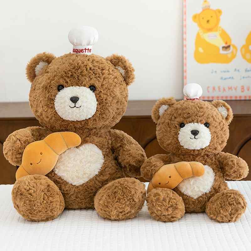 Bulk custom chef bear soft toys holding croissants in two sizes for boutique vendors.