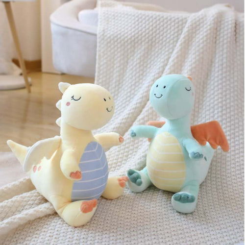 Bulk custom sleeping dinosaur stuffed animals in yellow and blue displayed on a blanket for vendors.