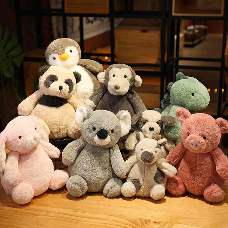 Bulk custom stuffed safari animal vendor catalog displaying nine chubby plush toys on a wooden table for boutique distributors.