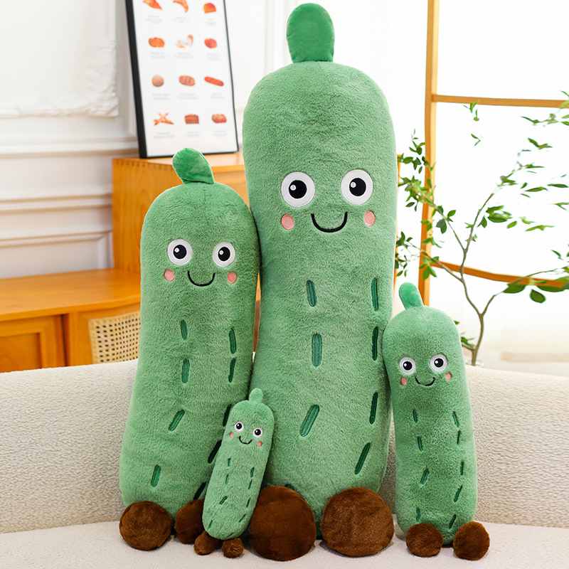 Collection of four cute cucumber plush toys in different sizes sitting on a sofa, kawaii emotional support stuffed animals for wholesale and room decor.