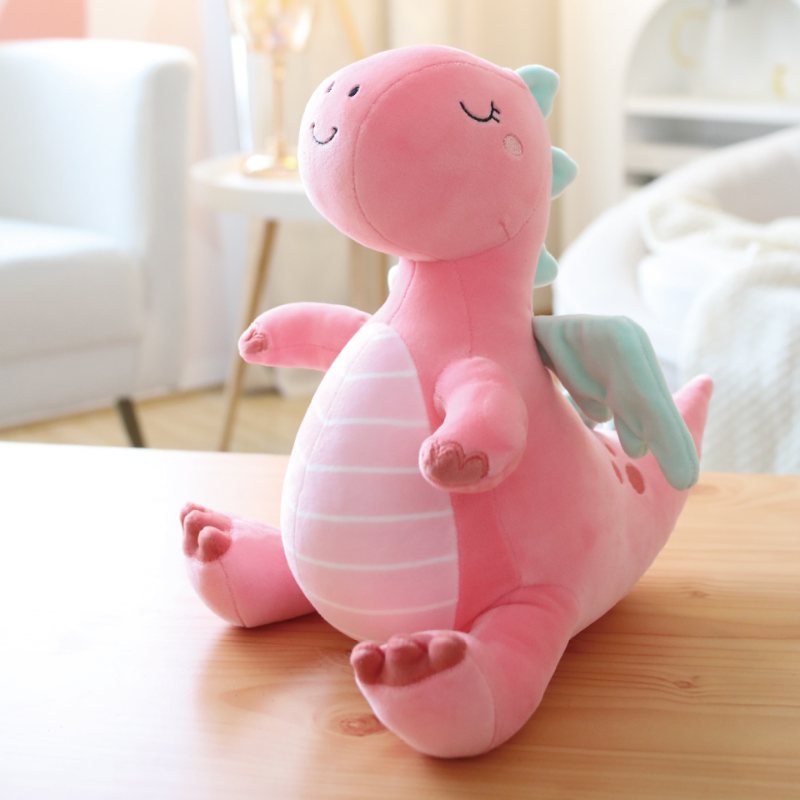 Custom pastel pink dragon plush toy displayed on a desk for wholesale gift shop sourcing.