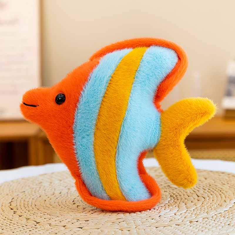 Custom stuffed orange angelfish soft toy resting on a woven mat for OEM manufacturing.