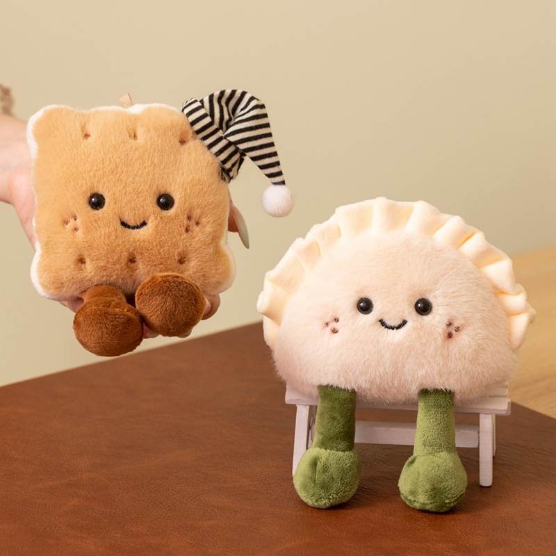 Hand holding sleepy biscuit plushie next to a smiling dumpling plush on a chair for factory-direct sourcing.