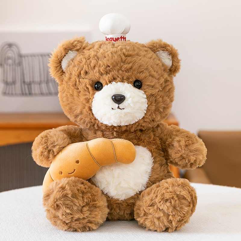 Factory-direct croissant bear plushie with chef hat for gift shop sourcing.