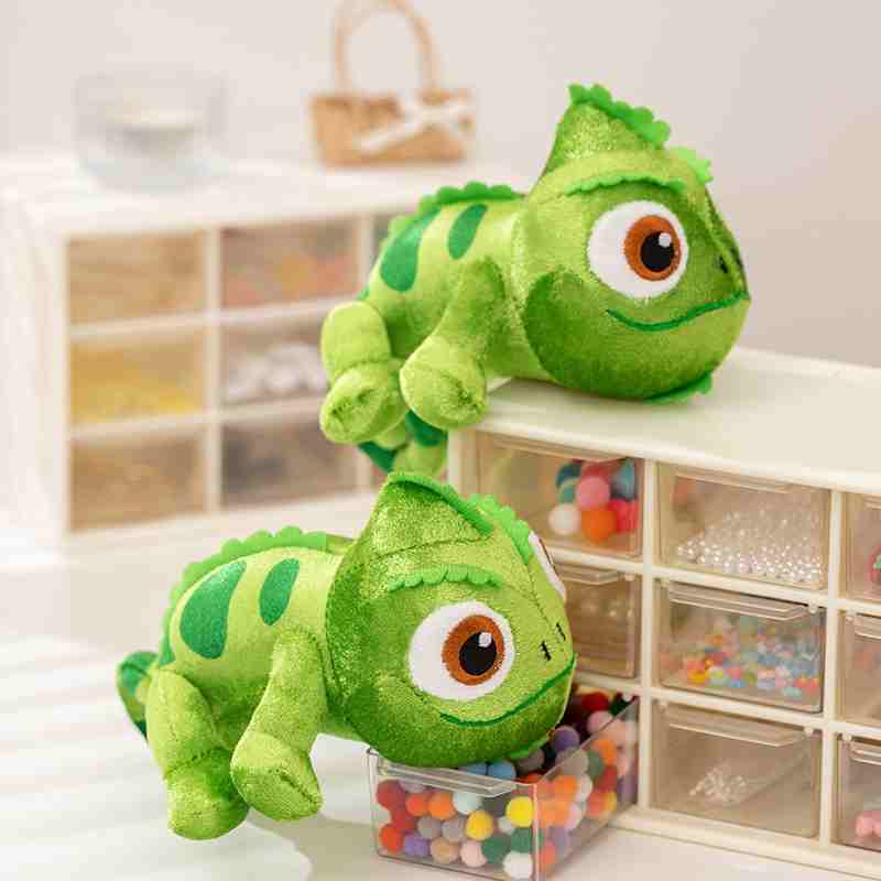 Factory-sourced custom reptile plushies sitting on desktop drawers, showcasing premium embroidery detailing for toy retail vendors.