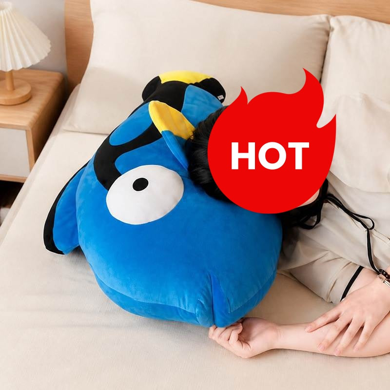 Model holding large and small blue tang fish plush toys by the window for wholesale sourcing.