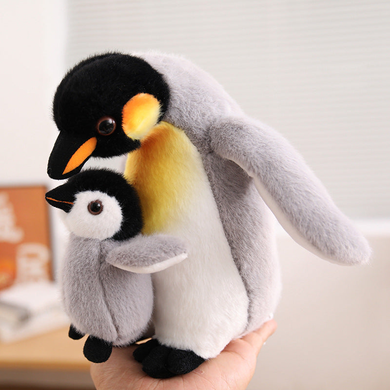 Factory-direct mother and baby penguin stuffed toy held by a model, demonstrating realistic plush textures for custom-branded toy vendors.