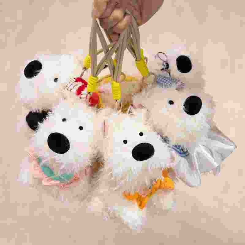 Factory-direct puppy plush pendants held by lanyards, showcasing retail distribution readiness for gift shops.