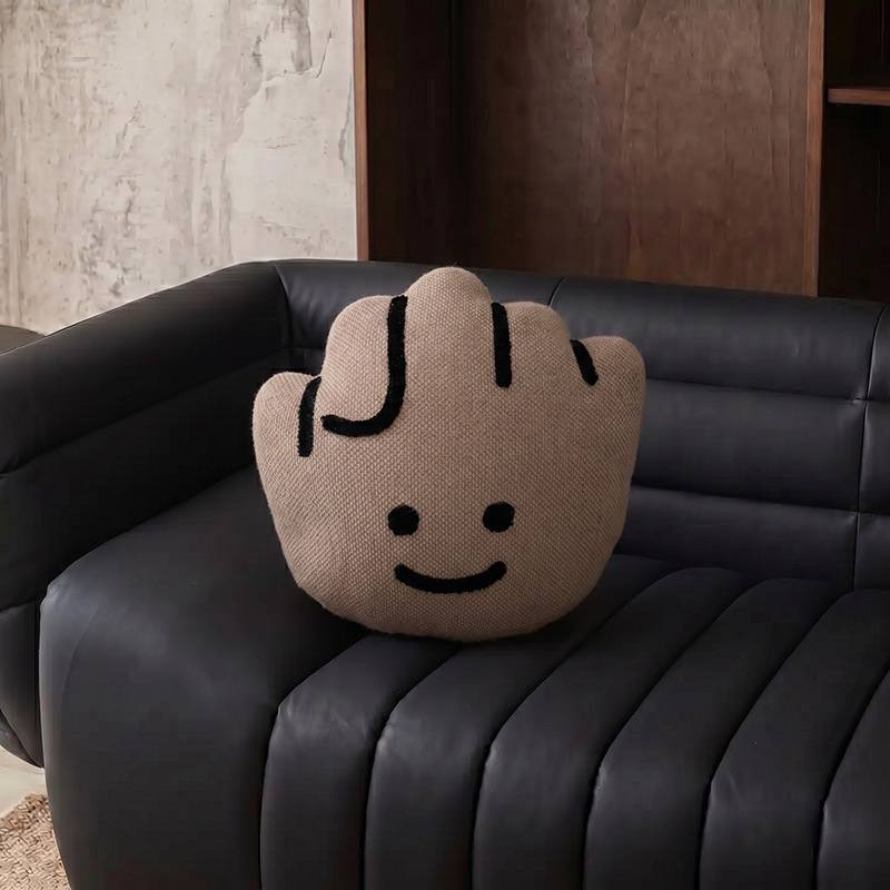 Factory direct rock fist shaped plush cushion on a black sofa for global wholesale.