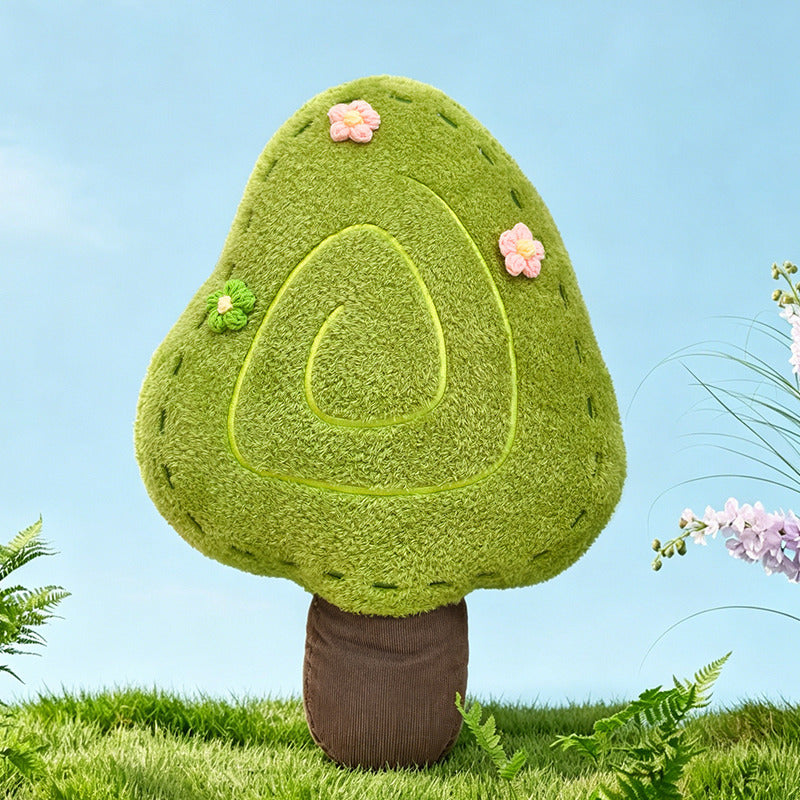 A nature-inspired green tree-shaped plush pillow with a unique spiral stitch design and small pink flowers, perfect for forest-themed nursery or minimalist living room decor.
