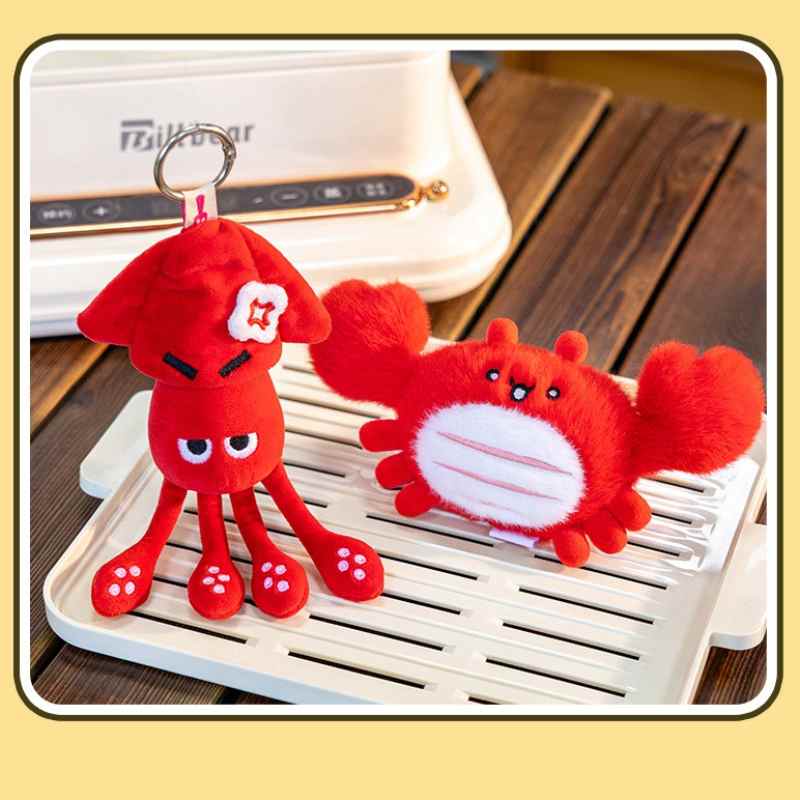 High-ROI angry red squid and chubby crab plush bag charms on a white tray, optimized for retail accessory distributors.