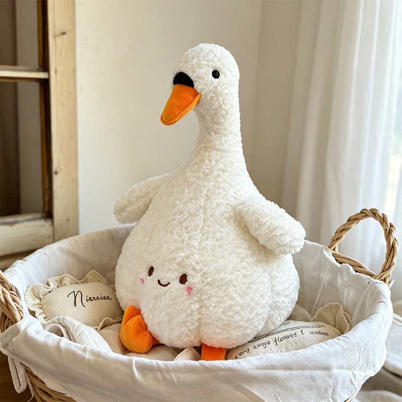 High-ROI cute white goose plushie sitting in a basket, optimized for retail gift shop distributors.