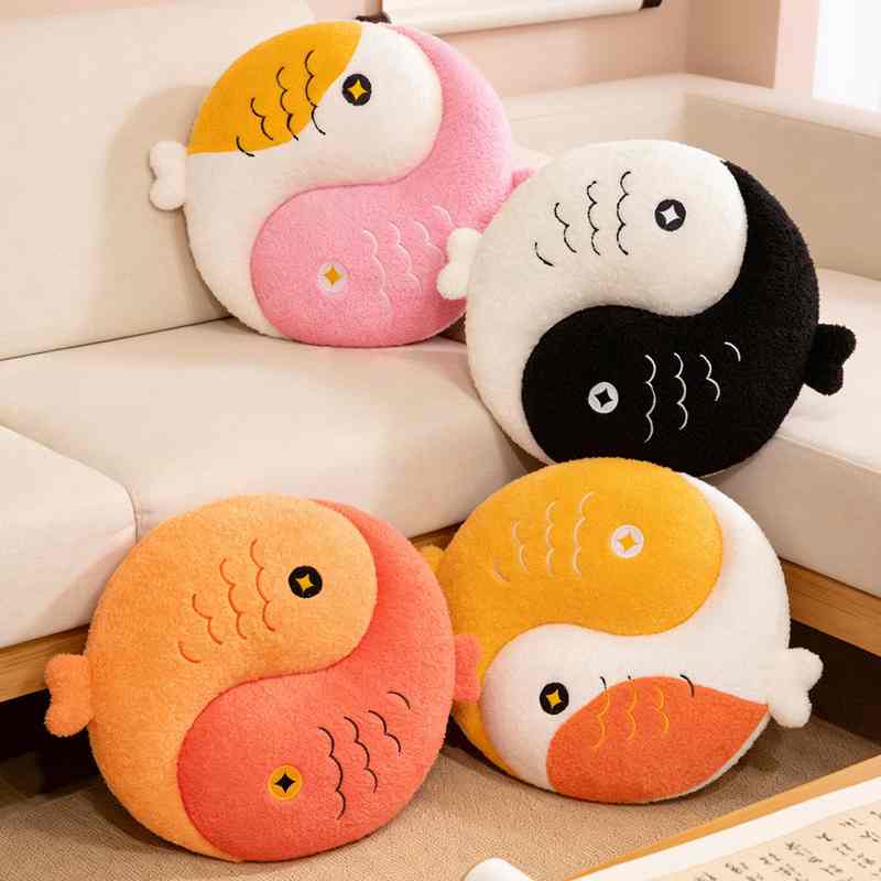 Four colorful Yin Yang Koi fish stuffed animal cushions arranged together in a cozy living room setting.