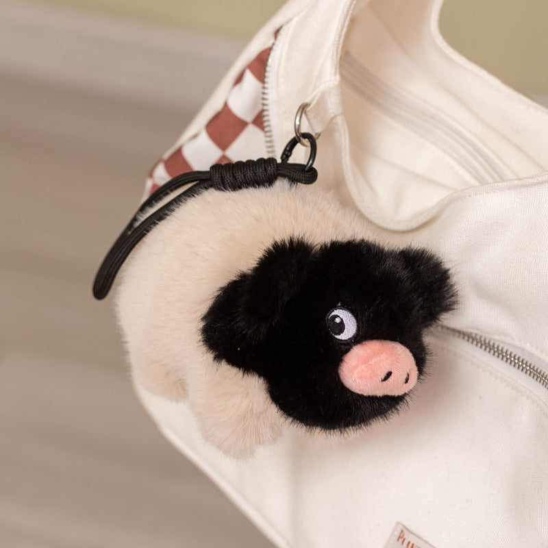 Kawaii  black-faced pig plush keychain hanging on a white bag, perfect aesthetic bag charm and accessory for girls.