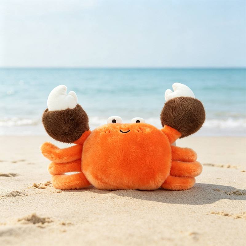 Premium boutique orange crab soft toy sitting on a sunny beach for wholesale sourcing.