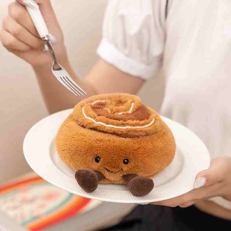 Wholesale kawaii cinnamon roll pastry plush displayed on a plate, maximizing impulse-buy appeal for aesthetic bakery cafes.