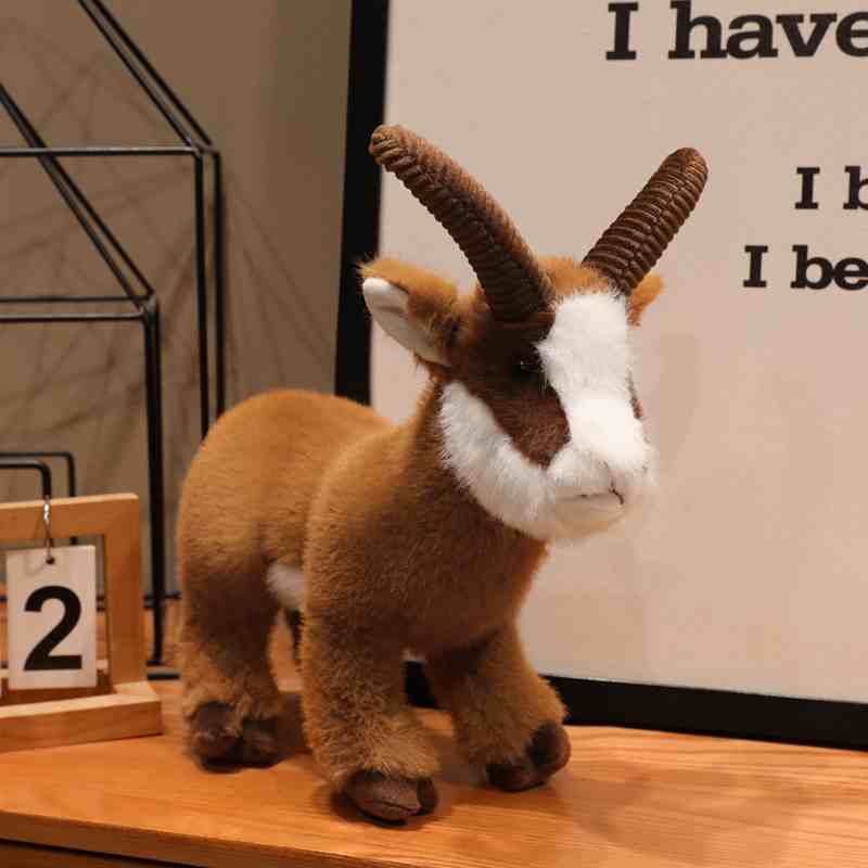 Premium dark brown ibex plush toy with realistic curved horns on a wooden desk, perfect for bulk retail wholesale.