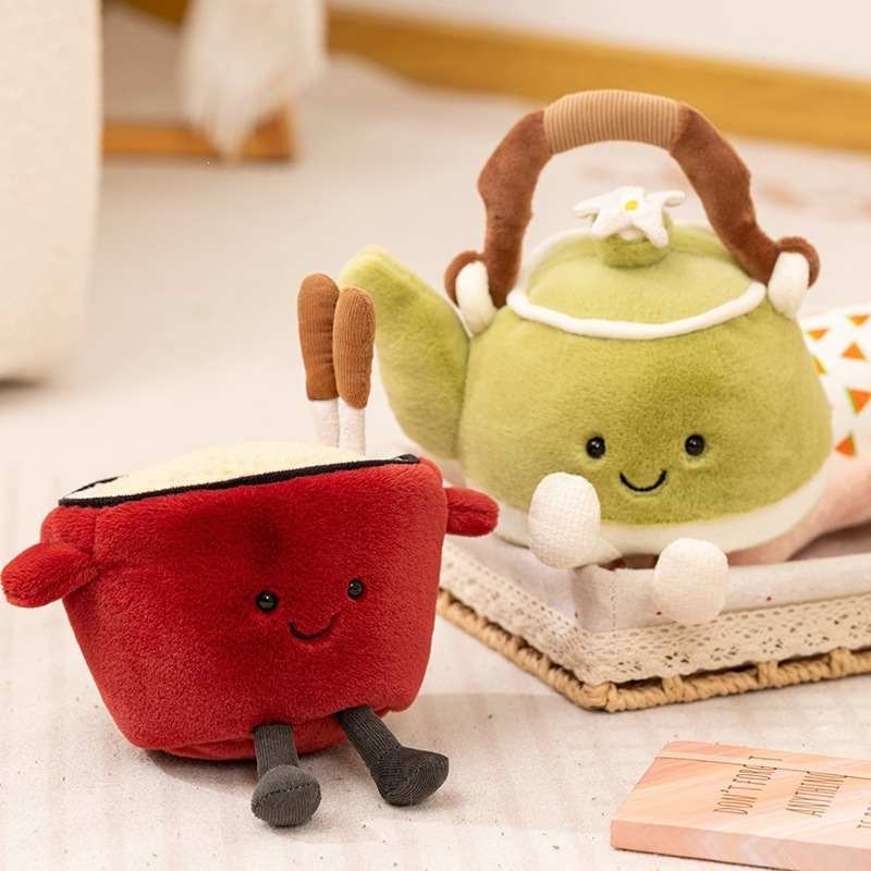 Premium green teapot plush and red noodle bowl plush displayed on a table for global wholesale distributors.