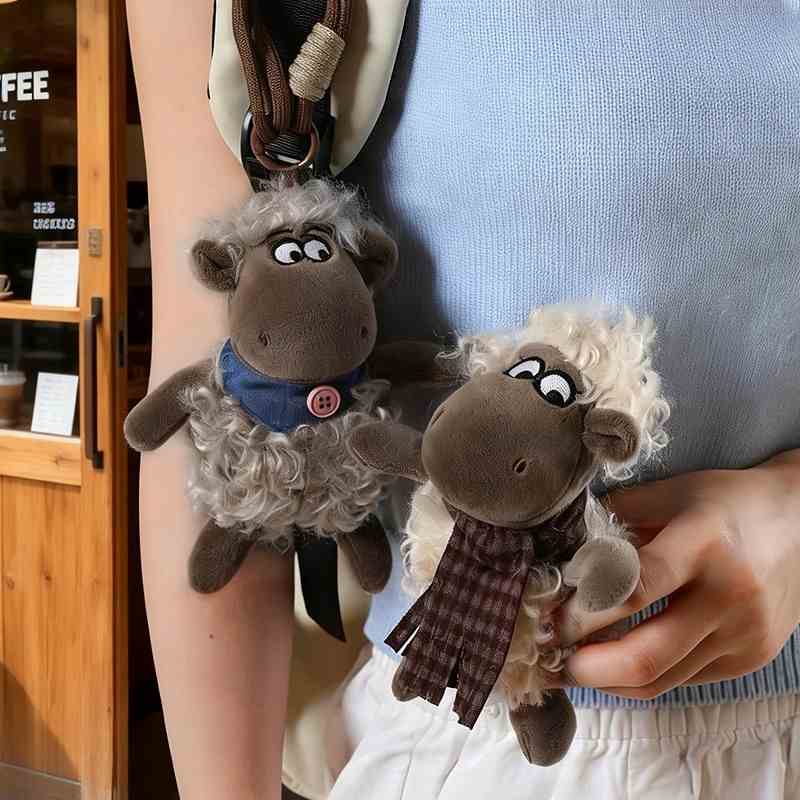 Mini sheep plush keychains attached to a shoulder bag for premium accessory suppliers.