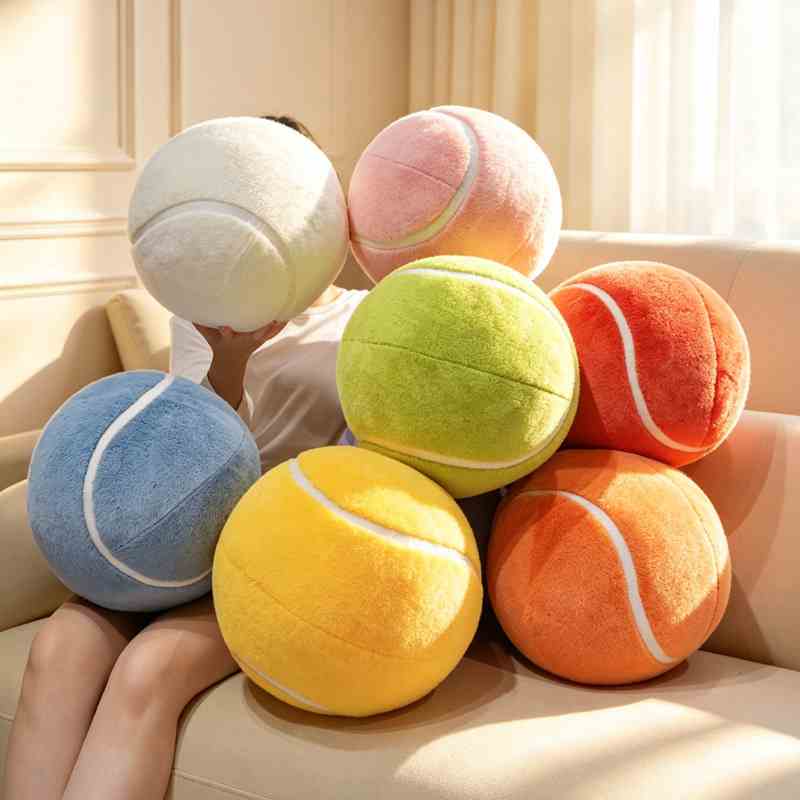 Premium soft tennis ball pillows in pastel colors held by a model, maximizing seasonal cottagecore and sports room decor retail appeal.