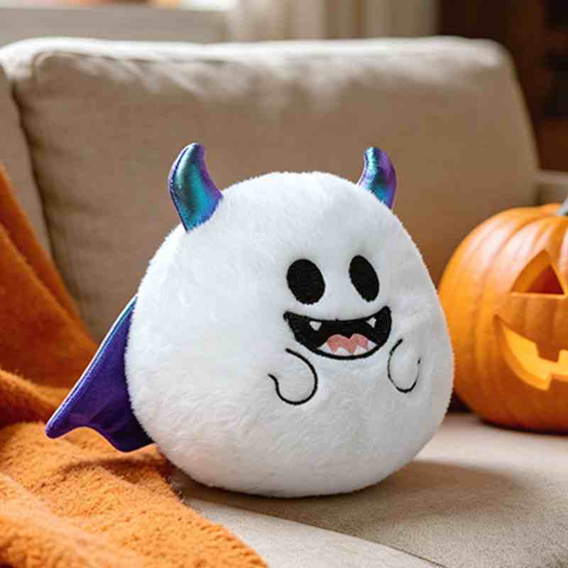 Premium white monster plushie with metallic purple horns on a sofa, showcasing custom embroidery detailing for holiday retail vendors.