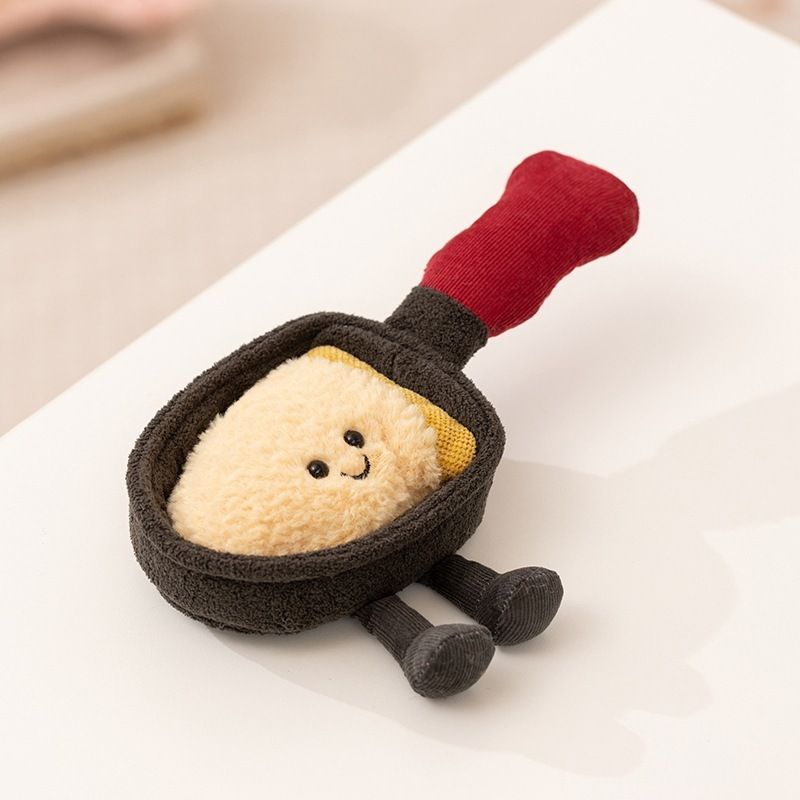 Private label plush frying pan with a smiling fried egg and brown dangling legs for B2B product lines.