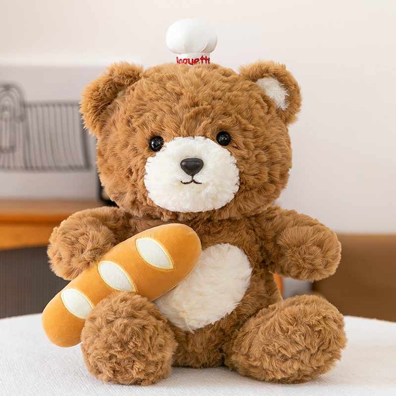Wholesale baker teddy bear holding a French baguette for B2B sourcing.