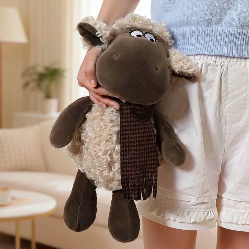 Model holding fluffy brown sheep plush toy wearing a plaid scarf for boutique wholesale.