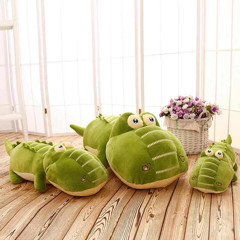 Wholesale giant crocodile plush toy assortment in three sizes on wooden floor for B2B sourcing.